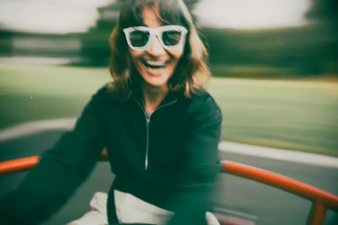 A woman riding a motorcycle down a street