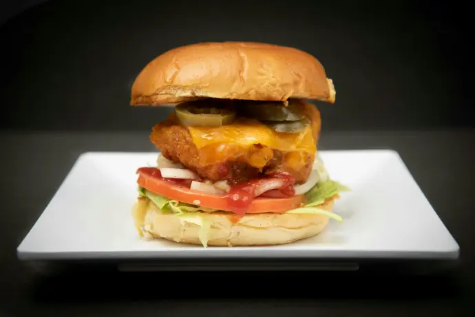 A cheeseburger on a plate with lettuce and tomatoes